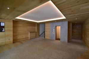 マドンナ・ディ・カンピリオにあるEmerald Studio Apartmentの木製の壁と天窓が備わる広い客室です。