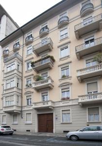 a building with balconies and a car parked in front of it at B&B Torino Crocetta in Turin