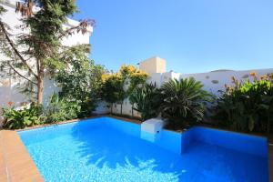 a swimming pool in the backyard of a house with plants at Villa Kamilari in Kamilari