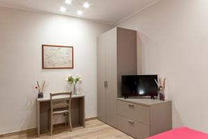 Cette chambre comprend un bureau, une télévision et un lit. dans l'établissement Casa marina, à Gênes