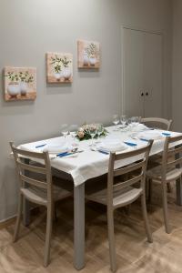 a white table with chairs and wine glasses on it at Casa marina in Genoa