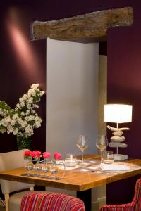 una mesa con copas de vino y flores. en Les Flots Bleus, en Beaulieu-sur-Dordogne