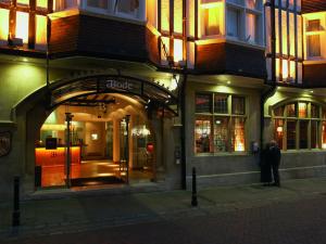 un hombre parado frente a una tienda por la noche en ABode Canterbury, en Canterbury