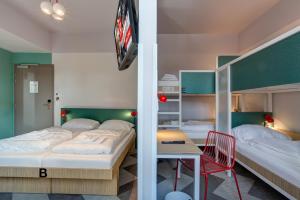 1 Schlafzimmer mit 2 Betten, einem Tisch und einem Schreibtisch in der Unterkunft MEININGER Hotel Paris Porte de Vincennes in Paris