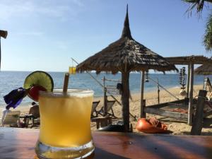 a drink sitting on a table on the beach at Coco Lanta Resort - SHA Extra Plus in Ko Lanta