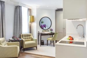 a kitchen and living room with a table and chairs at St. James' Court, A Taj Hotel, London in London