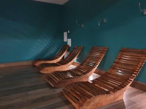 4 sillas en una habitación con una pared azul en DWIE SOSNY - Apartament Morski Kryształ - SAUNA, JACUZZI, SIŁOWNIA, BAWIALNIA - 365PAM, en Ustronie Morskie