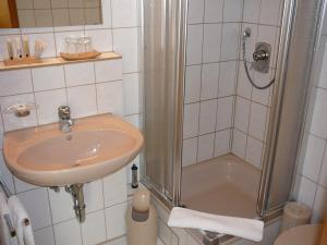 ein Bad mit einem Waschbecken und einer Dusche in der Unterkunft Hotel Garni Schmid in Neu Ulm