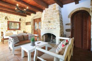 a living room with a couch and a fireplace at Villa Kamilari in Kamilari