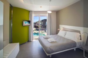 een slaapkamer met een bed met een groene muur bij Ciclope Resort in Acitrezza