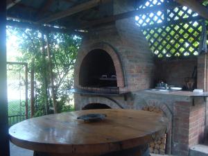 a brick oven with a wooden table in front of it at Pensiunea Nicky in Oeștii Ungureni