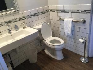 uma casa de banho com um WC branco e um lavatório. em The Ocean Bay House em Bay Shore