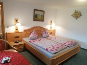 ein Schlafzimmer mit einem Bett mit Kissen darauf in der Unterkunft Gästehaus Marianndl in Schönau am Königssee