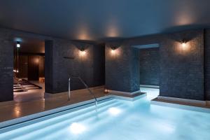a large swimming pool with lights in a room at St. James' Court, A Taj Hotel, London in London