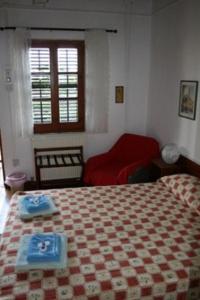 um quarto com uma cama e um sofá vermelho em The Bunch Of Grapes Inn em Pissouri
