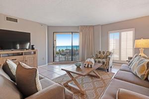 a living room with a couch and a tv and a table at Inlet Reef in Destin
