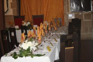una mesa larga con vasos y flores. en Hostal Restaurante La Diligencia en Cunit
