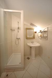 y baño con ducha, lavabo y bañera. en Apartments Villa Marnii, en Kožino