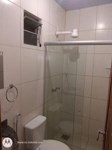 a bathroom with a toilet and a glass shower at Residencial Dom Fernando in Belém