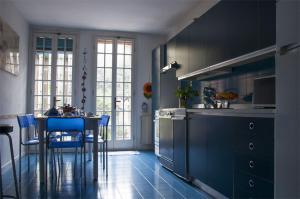 a kitchen with blue cabinets and a table with blue chairs at Gli Angeli in Venice