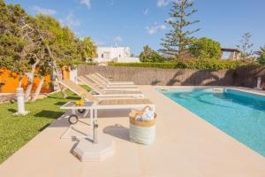 a group of chairs and a table next to a swimming pool at Villa Menorca 16 in Cala d´Or