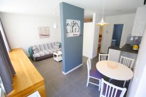 a living room with a table and a kitchen at Apartmani Luce in Zadar