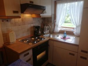 a kitchen with a sink and a stove and a window at Gästehaus Marianndl in Schönau am Königssee