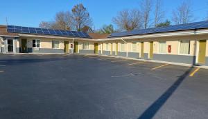 um parque de estacionamento vazio em frente a um edifício com painéis solares em Lodge Inn Wrightstown - Fort Dix em Wrightstown