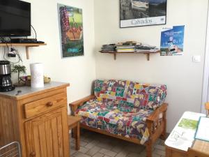 a living room with a couch and a tv at Au Bon Gite in Arromanches-les-Bains