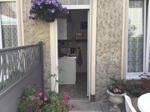 a house with a kitchen and a balcony with flowers at Au Bon Gite in Arromanches-les-Bains