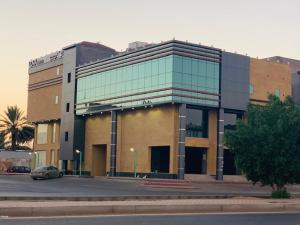 a building with a car parked in front of it at Lova Suites in Yanbu