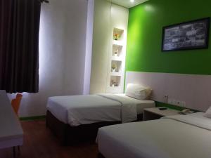 En eller flere senge i et værelse på Hotel DRAGON INN Kemayoran
