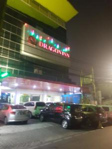 a car dealership with cars parked outside at night at Hotel DRAGON INN Kemayoran in Jakarta