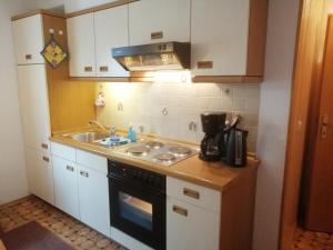 a kitchen with a sink and a stove top oven at Gästehaus Marianndl in Schönau am Königssee