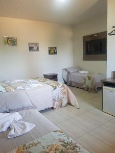 um quarto de hotel com duas camas e uma televisão em Hotel Refugio em Bonito