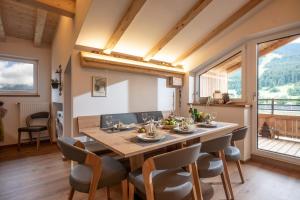 una sala da pranzo con un grande tavolo in legno e sedie di Marias Alpen Apartment a Brixen im Thale