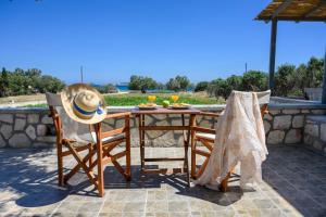 Alisea Resort في كيمولوس: طاولة مع قبعة وكرسيين على الفناء