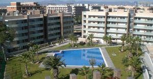 - une vue sur la piscine bordée de palmiers et de bâtiments dans l'établissement Ibersol Spa Aqquaria, à Salou