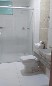 a bathroom with a toilet and a shower and a sink at Hotel Vista Bela in Itamaraju