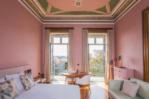 a bedroom with a large bed and a large window at Menina Colina Guesthouse in Porto