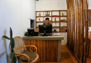 a man sitting at a desk with a laptop computer at Petit Espace Boutique Hostel in Vientiane