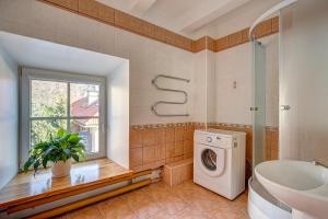 uma casa de banho com uma máquina de lavar roupa e uma janela em Vidos apartamentai 2 em Vilnius