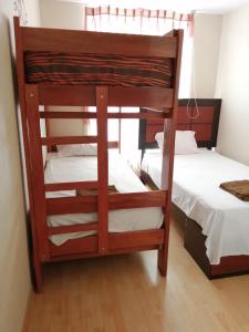 a bunk bed in a room with two beds at Peruvian Apartment in Lima