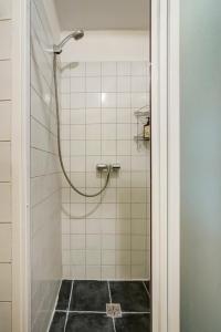 a shower with a hose in a bathroom at Vidos Apartamentai in Vilnius