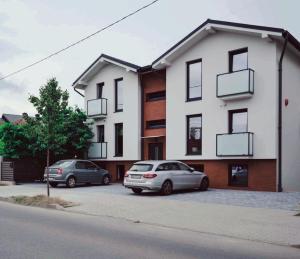 two cars parked in a parking lot in front of a building at Vila White Tulip in Alba Iulia