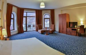 Habitación de hotel con cama y TV en El Resort Hotel, en Qax