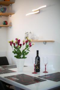 una mesa con una botella de vino y un jarrón con flores en Apartman Dora, en Korčula