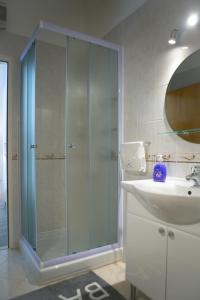 a bathroom with a glass shower and a sink at Apartman Dora in Korčula