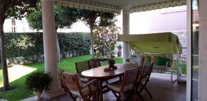 a porch with a table and chairs and a garden at El olivo in Tordesillas