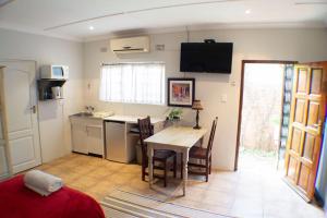 a room with a table and a kitchen with a table and chairs at A Place of Grace in Durban